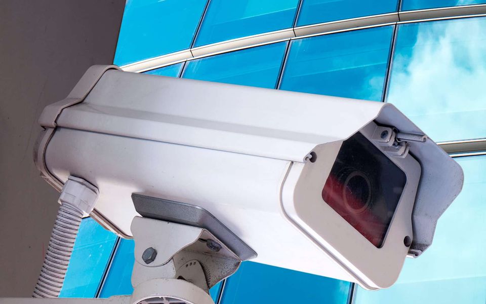 Cámara de videovigilancia instalada en una fachada de vidrio